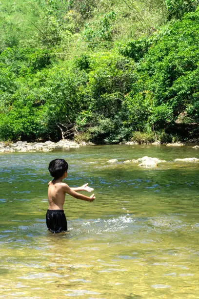 Asian boys playing water in the natural river.