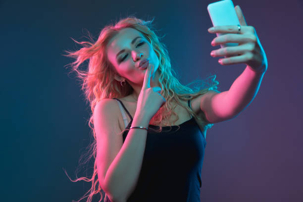 istock Caucasian young woman's portrait on gradient background in neon light 1184354375