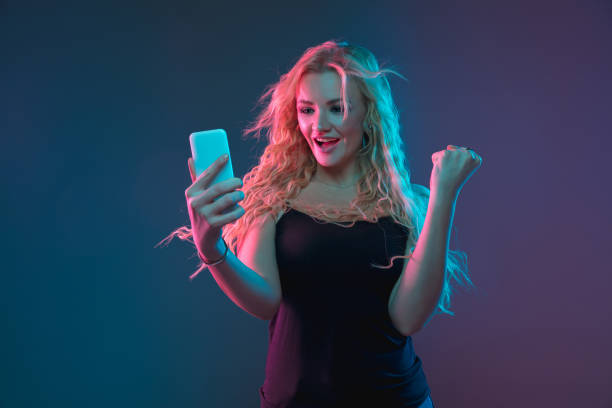 istock Caucasian young woman's portrait on gradient background in neon light 1184354377