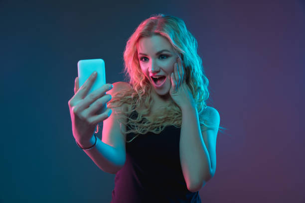 istock Caucasian young woman's portrait on gradient background in neon light 1184354380