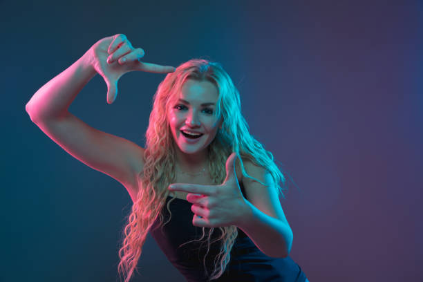 istock Caucasian young woman's portrait on gradient background in neon light 1184354408