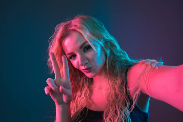 istock Caucasian young woman's portrait on gradient background in neon light 1184354430