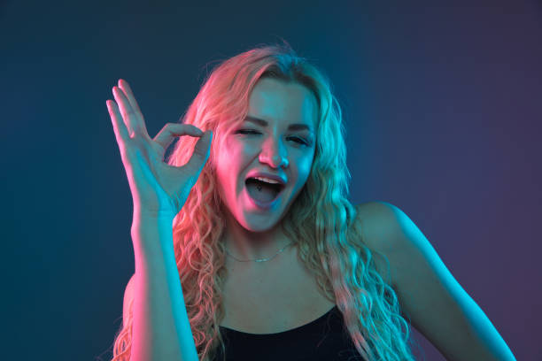 istock Caucasian young woman's portrait on gradient background in neon light 1184354431
