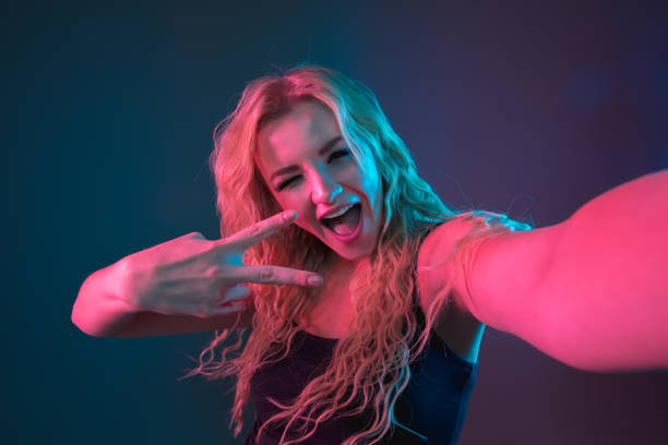 istock Caucasian young woman's portrait on gradient background in neon light 1184354438