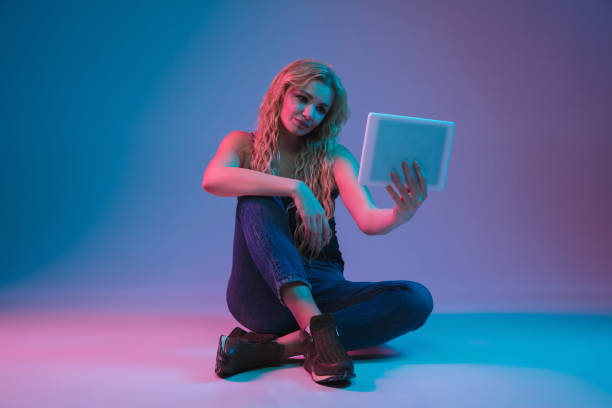 istock Caucasian young woman's portrait on gradient background in neon light 1184354458