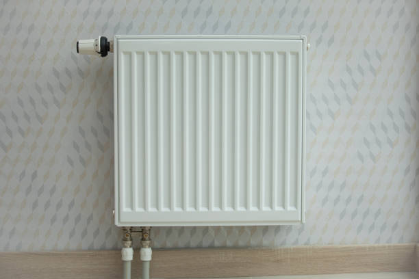 istock White radiator in an apartment. home heating 1184354491