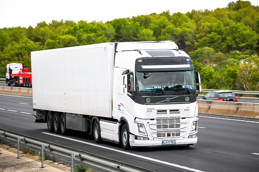 Occitanie, France - September 10, 2019: White semi-trailer truck Volvo FH12.500 at the interurban road.