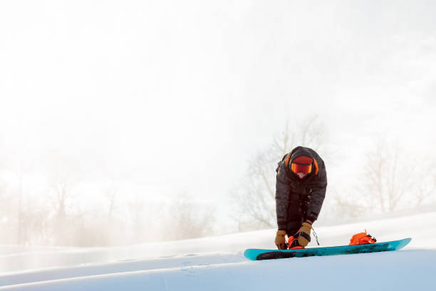 istock Snowboarder put on snowboard boots beffore the competition 1184359949