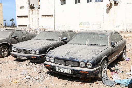 Casablanca, Morocco - September 29, 2019: Abandoned luxury cars Daimler Super V8 and Jaguar XJ Executive in the city street.