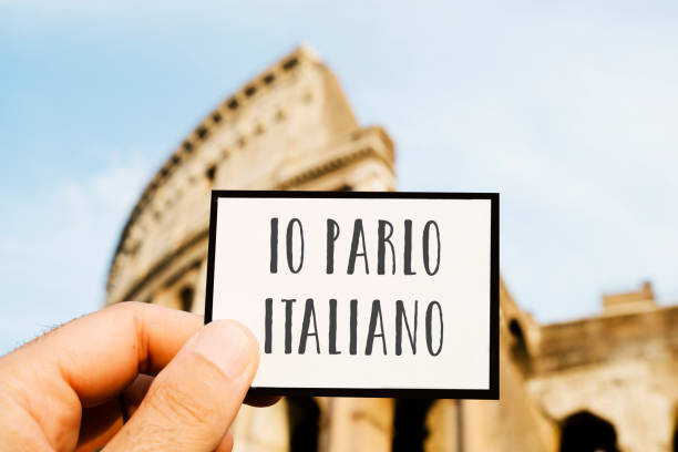 text I speak Italian, in Italian closeup of the hand of a caucasian man holding sign with the text io parlo italiano, I speak Italian, written in Italian, in front of the Flavian Amphitheatre or Colosseum, in Rome, Italy italian language stock pictures, royalty-free photos & images