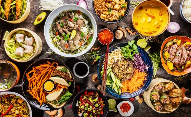 Top view composition of various Asian food in bowls, free space for text