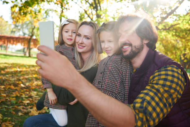 istock Happy family making a selfie in autumn forest 1184365843