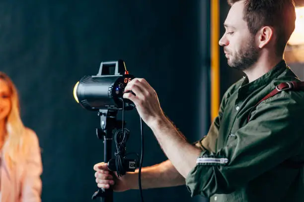 Photo of young beaded man setting the flash