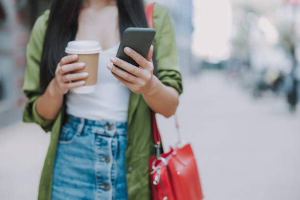 istock Young lady is standing with hot drink outdoors 1184369044