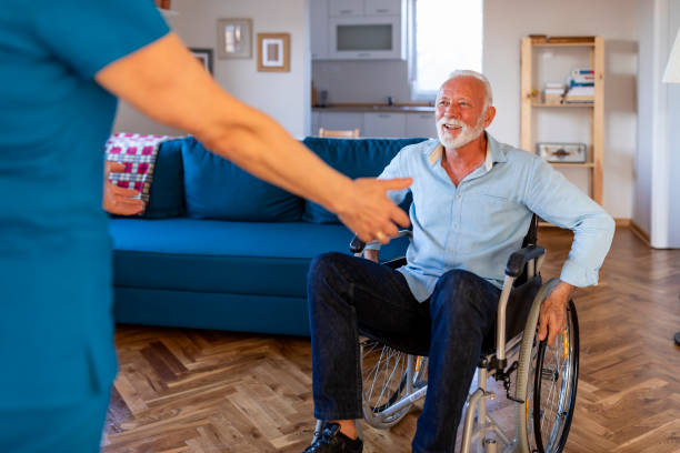 istock Receiving professional, compassionate, and personalized care. Carer helping an elderly man in a wheelchair 1184369901