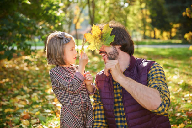 istock Father and daughter picking autumnal leafs 1184370259
