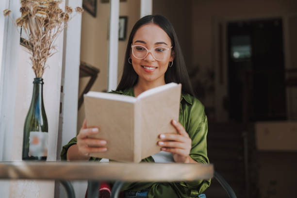 istock Smiling pretty lady is holding book in cafe 1184371210