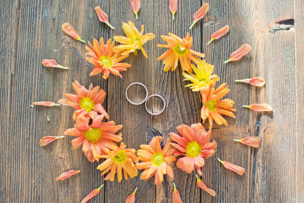 istock wedding rings and orange chrysantemums 1184372147