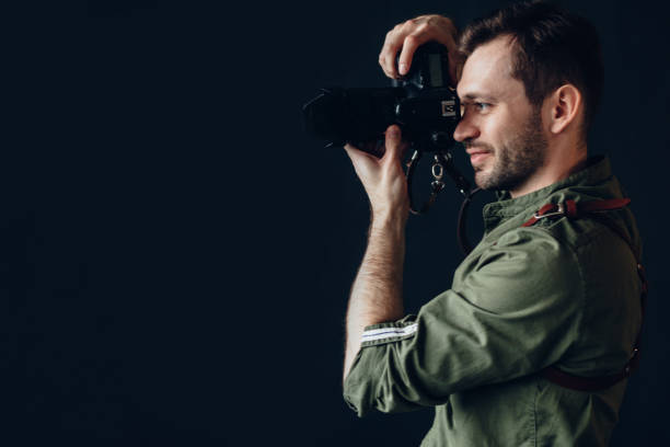 istock Side view photo of a handsome man taking photo with digital camera. 1184374845