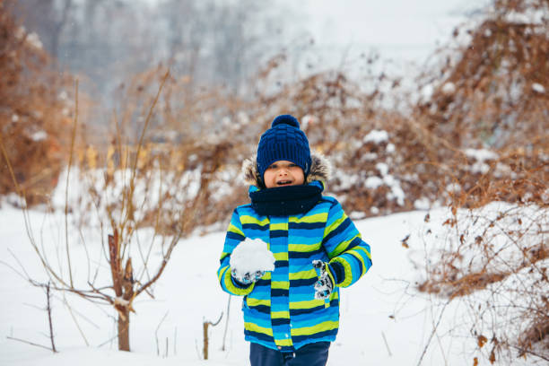 istock little boy playing with snow. making snowballs. winter time 1184375283