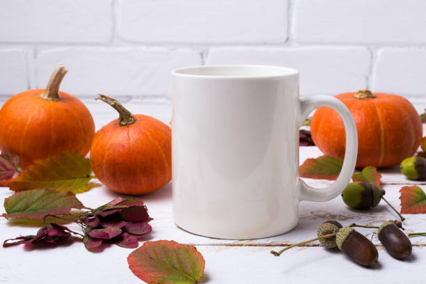istock White coffee mug mockup with pumpkins, acorns 1184376354