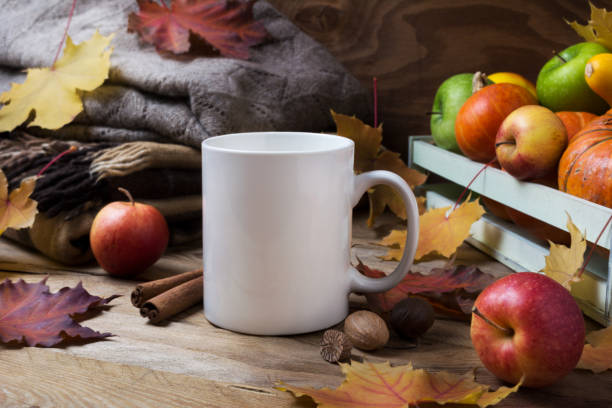istock White coffee mug mockup with fall leaves and knitted plaid 1184376365