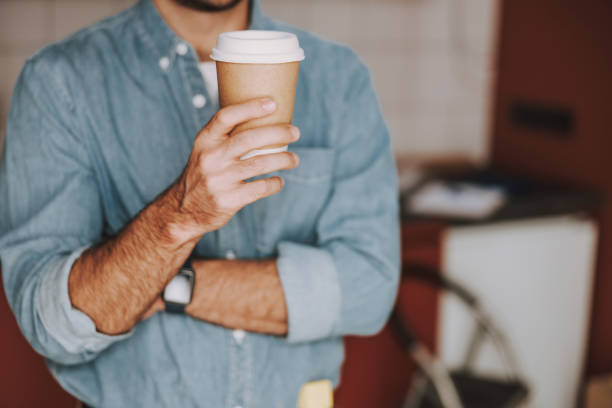 istock Man is holding hot drink in hand 1184378580