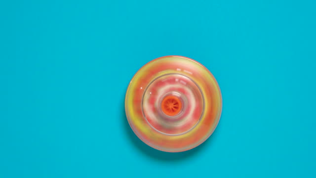 Colorful spinning top toy on blue background