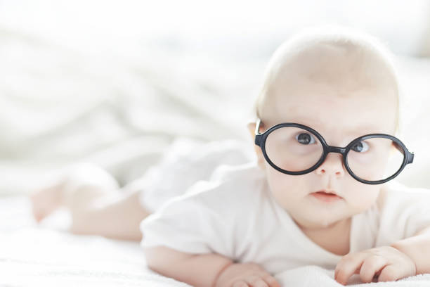 istock A newborn baby is lying on a soft bed in glasses. 1184380350