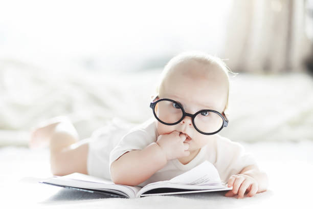 istock A newborn baby is lying on a soft bed in glasses. 1184380511