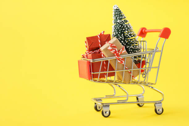 istock Shopping cart full of various gift boxes and a Christmas tree. 1184382448