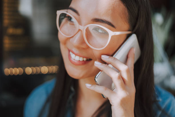 istock Smiling young lady is talking on smartphone outdoors 1184383981