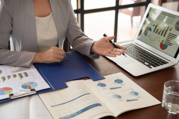 Business women working Business women reviewing data in financial statement with coworker analyzing market data research for new business startup. briefcase stock pictures, royalty-free photos & images