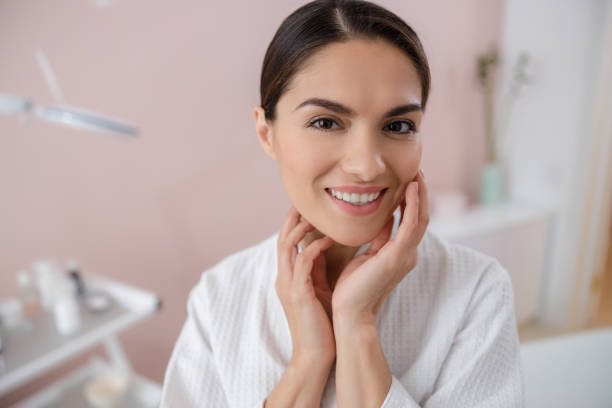 istock Beautiful young woman touching her face and smiling 1184388978