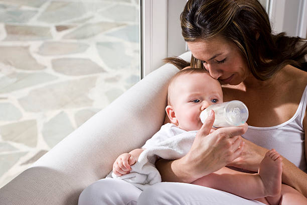 istock Affectionate mother feeding bottle to six month old baby 118439054