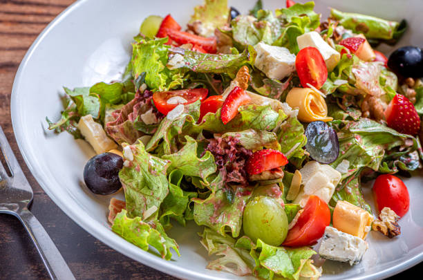 istock Gourmet green salad with cheese, grape, strawberries and cherry 1184391943