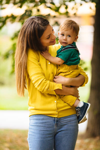 istock Beautiful young mother holding her baby boy 1184392473