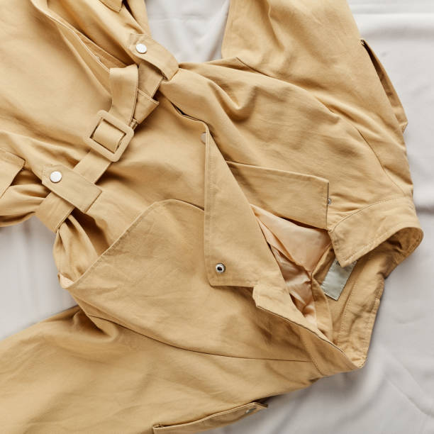 istock Warm autumn coat lying on the white background 1184393360