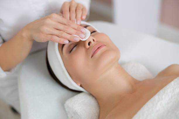 istock Beautician hands cleaning lady face before the procedure 1184393788