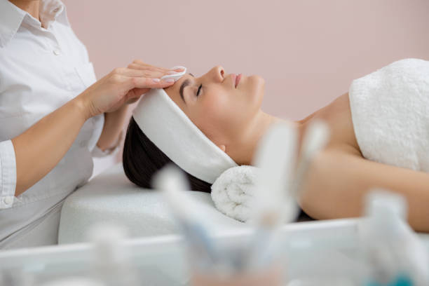 istock Cosmetologist removing impurities from lady face with cotton pads 1184393802