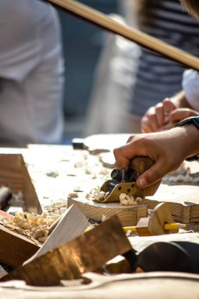 les enfants apprennent à faire du violon personnalisé et d'autres instruments de musique dans les classes de fablab en plein air. formation de joiner sur makerfaire. - fertigung photos et images de collection