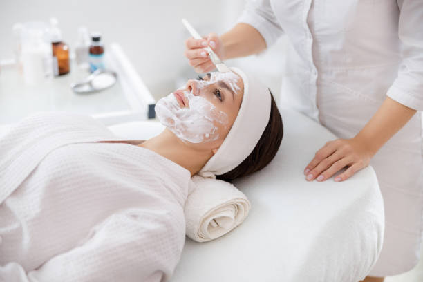 istock Beautician applying cosmetic mask on lady face 1184394947