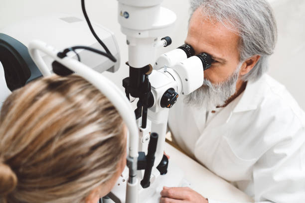 istock Professional optician examining woman with modern optical equipment 1184395169