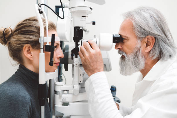 istock Professional optician examining woman with modern optical equipment 1184395178