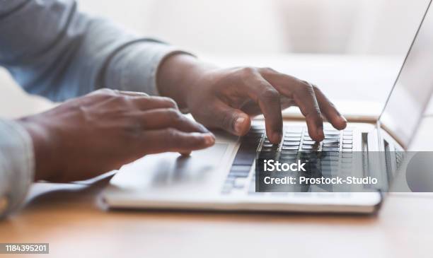 Unrecognizable African American Man Typing On Laptop Keyboard In Office Stock Photo - Download Image Now