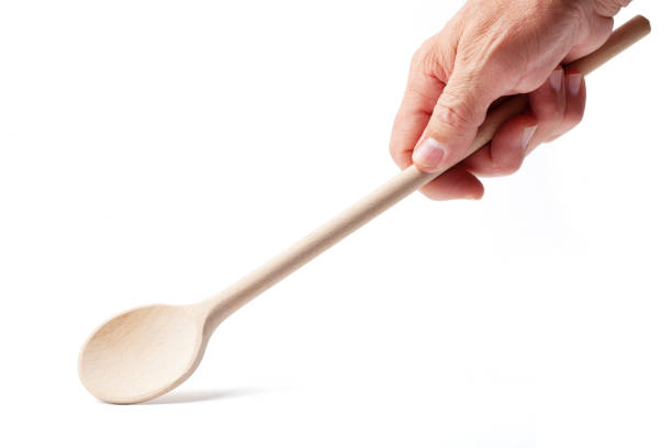 Hand with a Wooden Cooking Spoon on White stock photo