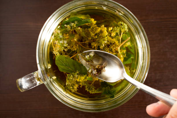 young woman making hot herbal tea in a kitchen