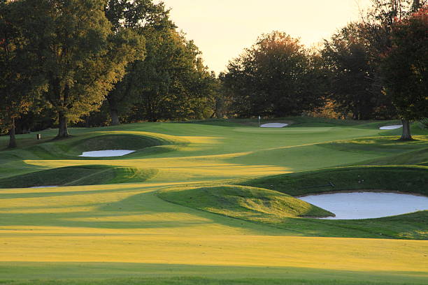 golfplatz im herbst bei sonnenuntergang - golf golf flag sunset flag stock-fotos und bilder