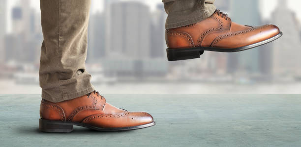 istock Man takes a step in classic shoes 1184399093