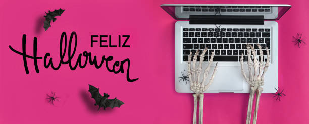 mani scheletro che digitano laptop e testo di halloween in spagnolo - skeleton key key computer keyboard laptop foto e immagini stock
